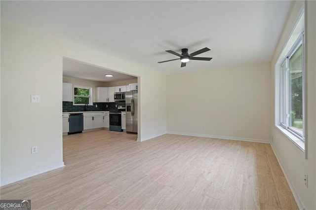 8432 Magnolia Dr, Jonesboro, GA 30238 - unfurnished living room with light wood-style floors, ceiling fan, a sink, and baseboards