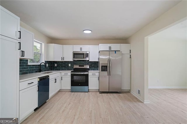 8432 Magnolia Dr, Jonesboro, GA 30238 - kitchen featuring stainless steel appliances, a sink, light wood-style flooring, light countertops, and tasteful backsplash