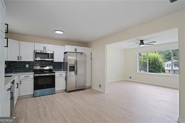 8432 Magnolia Dr, Jonesboro, GA 30238 - kitchen featuring appliances with stainless steel finishes, light countertops, backsplash, light wood finished floors, and baseboards