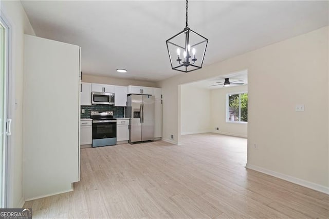 8432 Magnolia Dr, Jonesboro, GA 30238 - kitchen with stainless steel appliances, a chandelier, white cabinetry, and light wood-style flooring