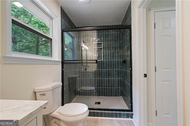 8432 Magnolia Dr, Jonesboro, GA 30238 - bathroom featuring a shower stall, toilet, vanity, and wood finished floors
