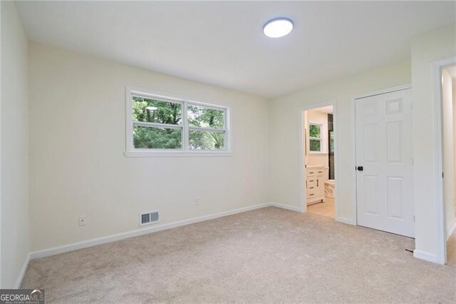 8432 Magnolia Dr, Jonesboro, GA 30238 - unfurnished bedroom with light colored carpet, baseboards, and ensuite bathroom