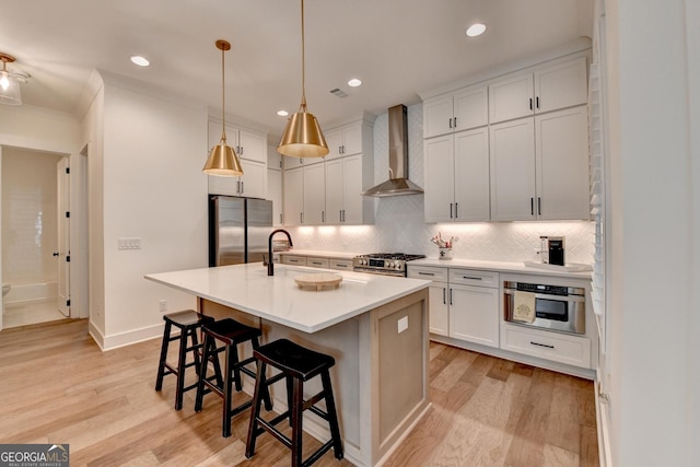 kitchen with stainless steel appliances, wall chimney exhaust hood, light wood-style flooring, decorative backsplash, and recessed lighting