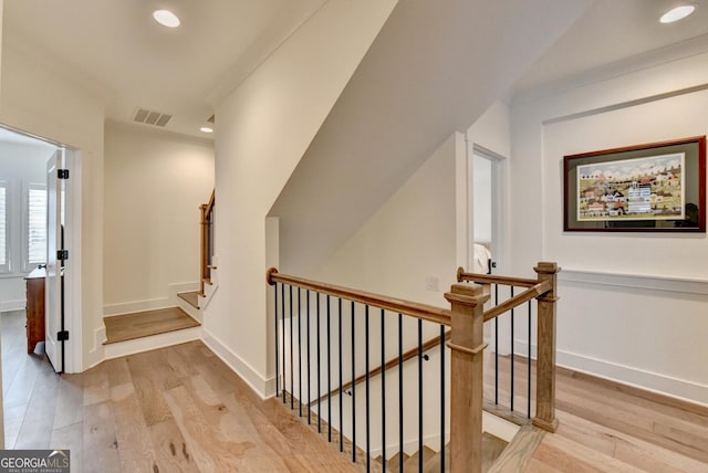 hallway featuring light wood finished floors, recessed lighting, an upstairs landing, and baseboards