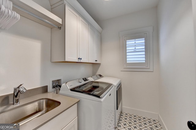laundry room with separate washer and dryer, cabinet space, and baseboards