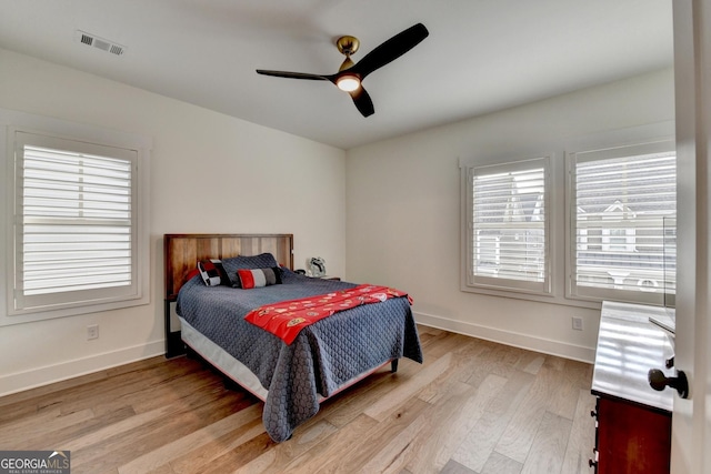 bedroom featuring light wood-style flooring, multiple windows, and baseboards