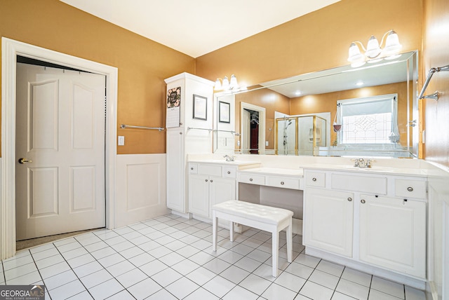 725 Windsor Place Cir SW, Grayson, GA 30017 - bathroom with a stall shower, a wainscoted wall, double vanity, tile patterned flooring, and a decorative wall