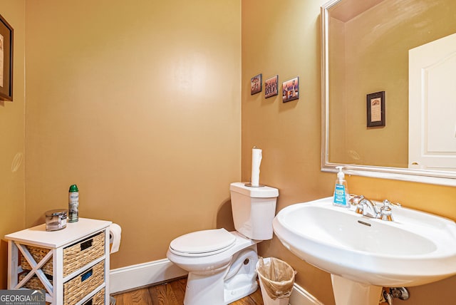 725 Windsor Place Cir SW, Grayson, GA 30017 - bathroom with baseboards, a sink, toilet, and wood finished floors