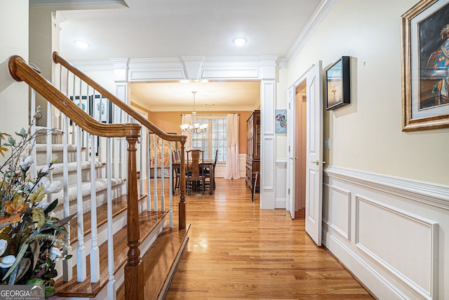 725 Windsor Place Cir SW, Grayson, GA 30017 - hall with a chandelier, crown molding, light wood-type flooring, stairs, and a decorative wall