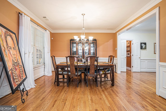 725 Windsor Place Cir SW, Grayson, GA 30017 - dining area with a chandelier, healthy amount of natural light, light wood-style floors, crown molding, and wainscoting