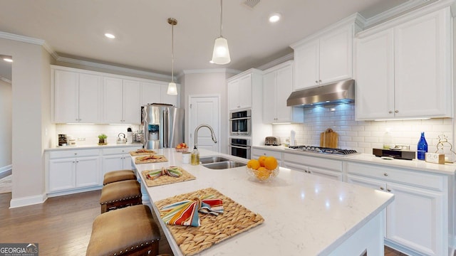 100 Maple Leaf Rd, Sharpsburg, GA 30277 - kitchen featuring stainless steel appliances, under cabinet range hood, a breakfast bar area, white cabinetry, and ornamental molding