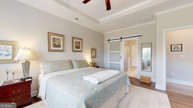 100 Maple Leaf Rd, Sharpsburg, GA 30277 - bedroom with a barn door, wood finished floors, ornamental molding, and a ceiling fan