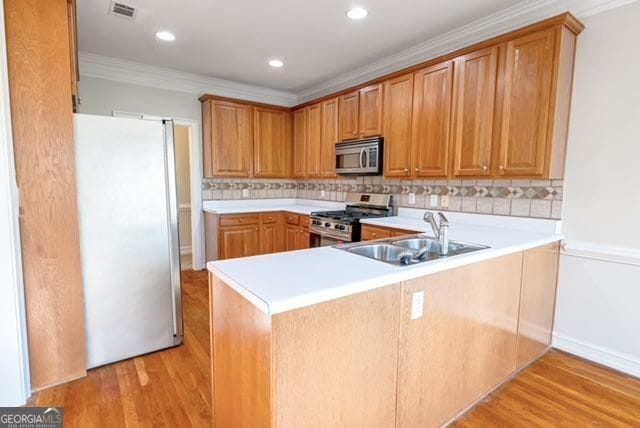161 Pleasant Grove Rd, Mcdonough, GA 30252 - kitchen featuring appliances with stainless steel finishes, a sink, ornamental molding, light countertops, and decorative backsplash