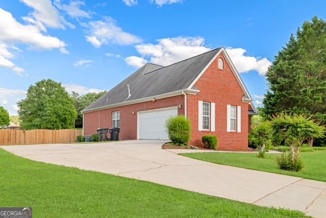 161 Pleasant Grove Rd, Mcdonough, GA 30252 - view of home's exterior with brick siding, driveway, and a garage