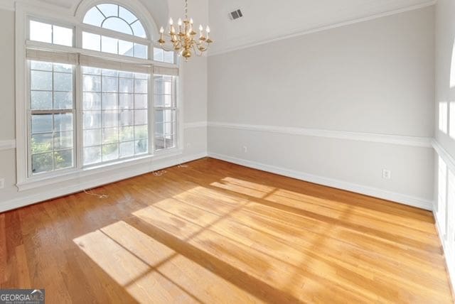 161 Pleasant Grove Rd, Mcdonough, GA 30252 - unfurnished dining area with a chandelier, ornamental molding, wood finished floors, and baseboards