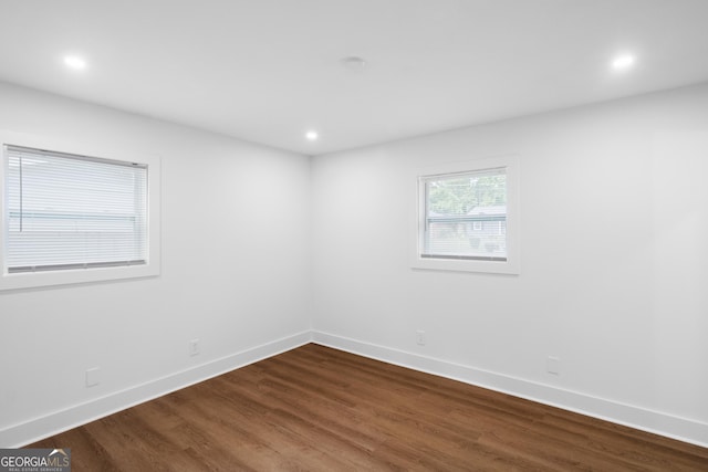 empty room featuring baseboards, dark wood finished floors, and recessed lighting