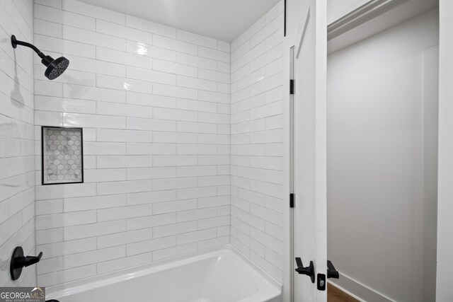 bathroom with tub / shower combination and baseboards