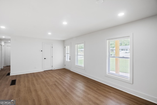 unfurnished living room featuring wood finished floors, baseboards, and recessed lighting