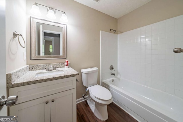bathroom with wood finished floors, toilet, vanity, and shower / bathtub combination