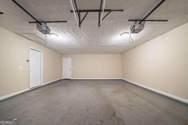 garage featuring a garage door opener and baseboards