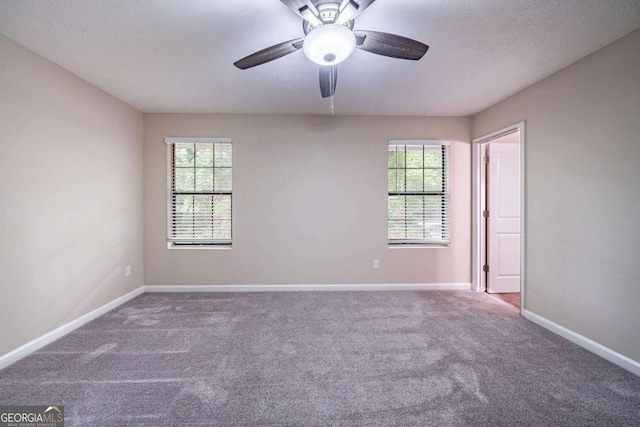 spare room with carpet floors, healthy amount of natural light, baseboards, and a ceiling fan