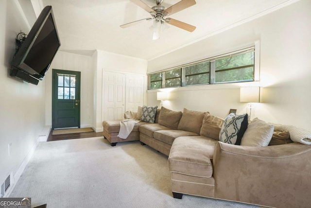 living room featuring ceiling fan, carpet floors, baseboards, and crown molding