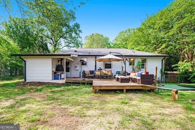 rear view of property featuring an outdoor hangout area, a wooden deck, and brick siding
