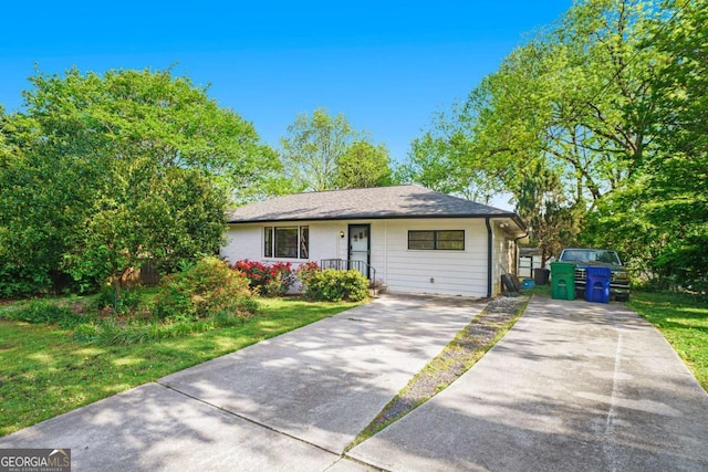 view of front facade featuring concrete driveway and a front lawn