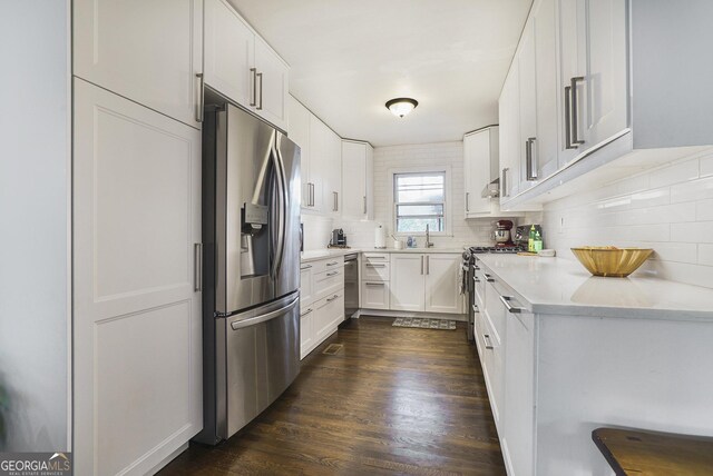 4128 Morgan Rd, Tucker, GA 30084 - kitchen featuring appliances with stainless steel finishes, backsplash, light countertops, white cabinets, and dark wood-style floors