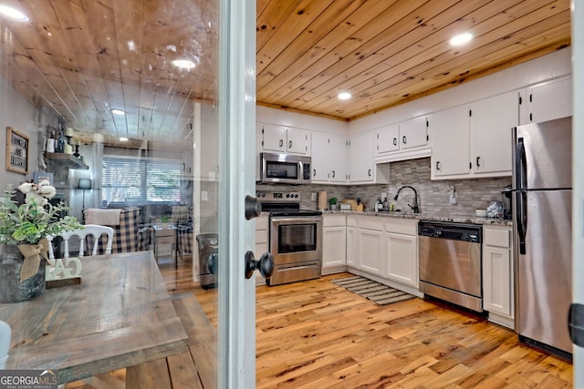 kitchen featuring stainless steel appliances, light wood-style flooring, white cabinets, wooden ceiling, and a sink