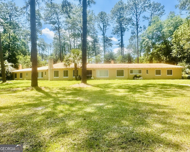 1002 Cherokee Cir, Waycross, GA 31501 - view of front of home with a chimney, a front yard, and view of wooded area