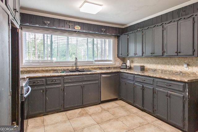 kitchen with appliances with stainless steel finishes, a sink, healthy amount of natural light, light tile patterned floors, and ornamental molding