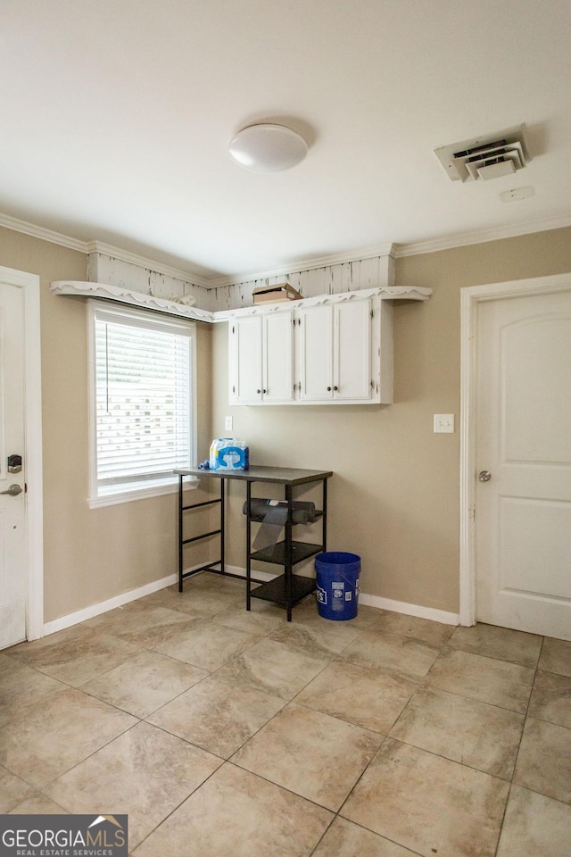 clothes washing area featuring crown molding, baseboards, and light tile patterned floors