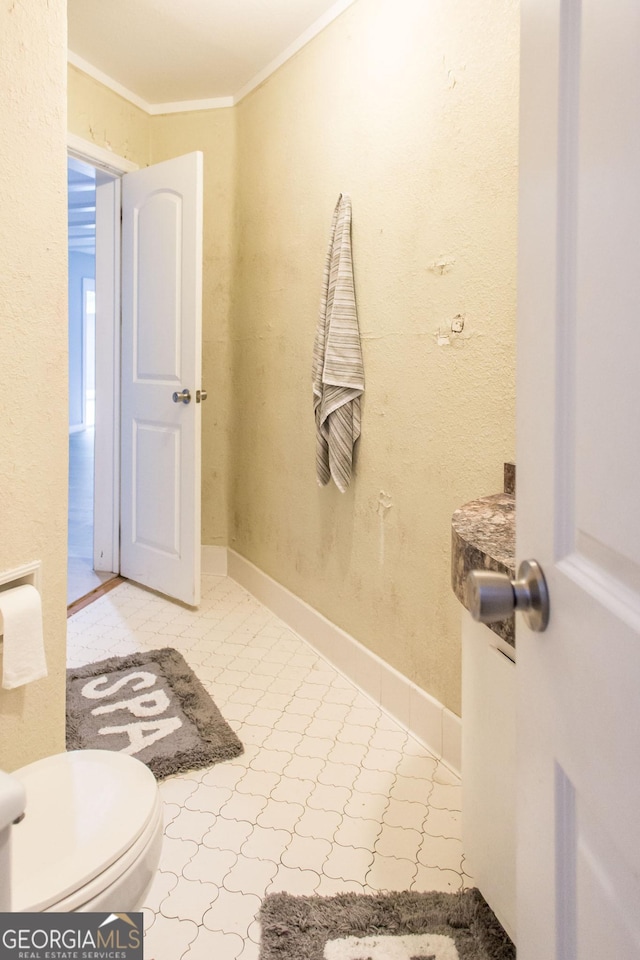 bathroom with ornamental molding, toilet, and tile patterned floors