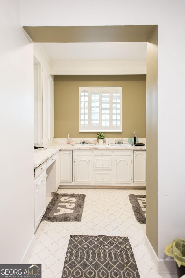 1002 Cherokee Cir, Waycross, GA 31501 - kitchen featuring white cabinetry, light countertops, a sink, and crown molding