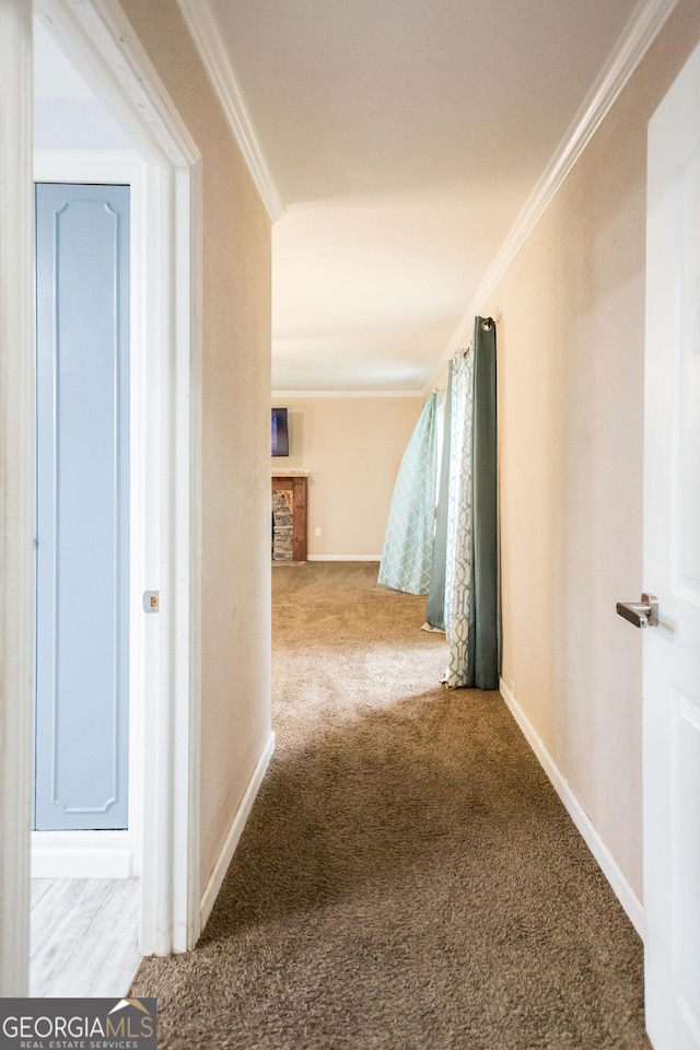 corridor with ornamental molding, carpet flooring, and baseboards
