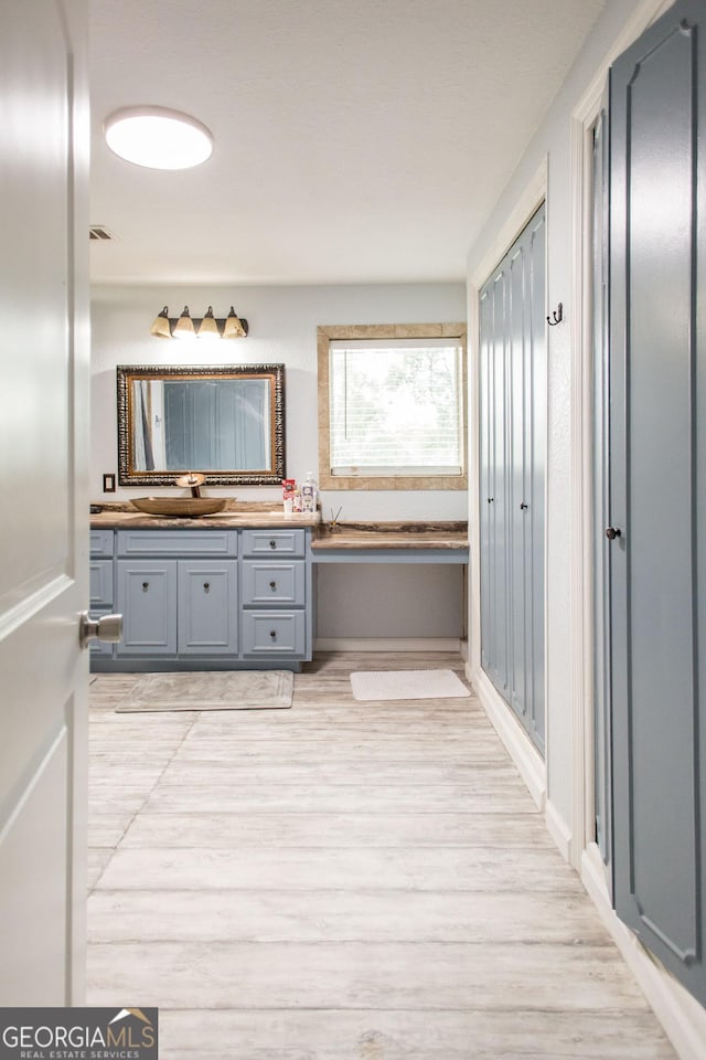 1002 Cherokee Cir, Waycross, GA 31501 - full bath featuring vanity, wood finished floors, and a garden tub