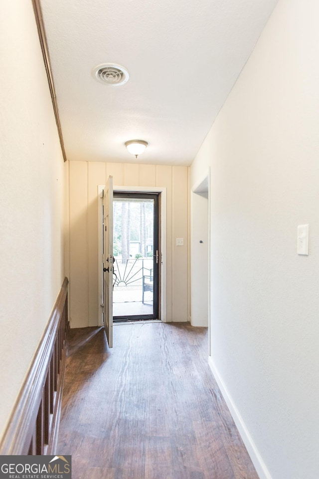 doorway to outside featuring wood finished floors and baseboards