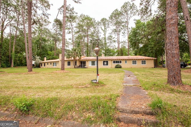 single story home with a front lawn and view of scattered trees