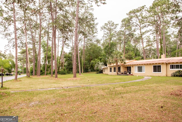 view of grassy yard with view of scattered trees