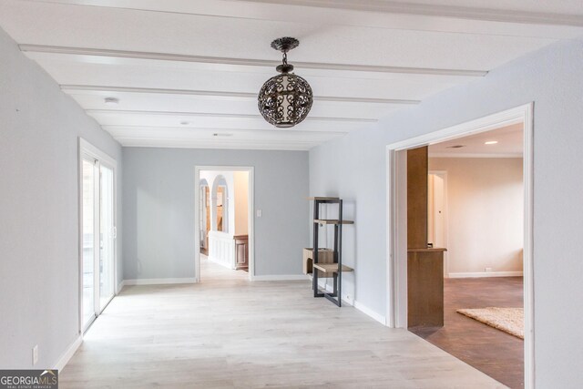 hallway with light wood-type flooring, beamed ceiling, arched walkways, and baseboards