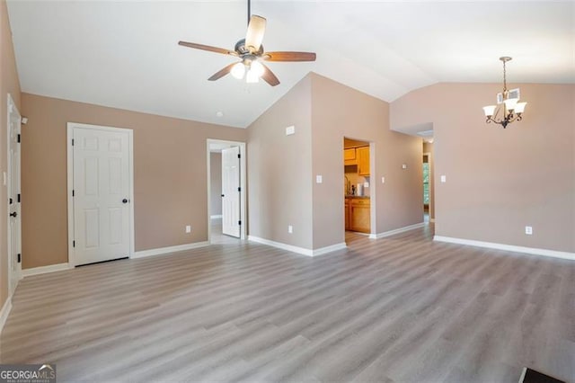 5805 Eagles Feather Ln, Riverdale, GA 30274 - unfurnished living room featuring lofted ceiling, a chandelier, a ceiling fan, light wood-type flooring, and baseboards