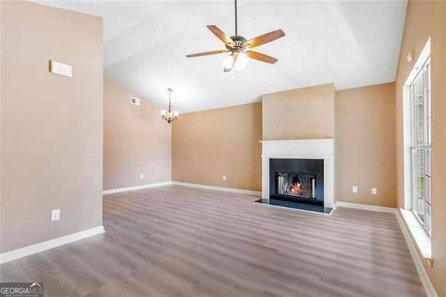 5805 Eagles Feather Ln, Riverdale, GA 30274 - unfurnished living room with lofted ceiling, baseboards, wood finished floors, a lit fireplace, and a chandelier