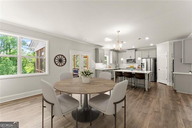 dining area with ornamental molding, dark wood-type flooring, recessed lighting, baseboards, and a chandelier