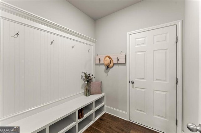 mudroom with dark wood finished floors and baseboards