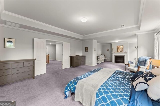 bedroom featuring carpet floors, a tray ceiling, crown molding, baseboards, and a fireplace
