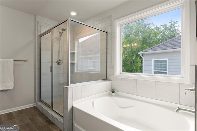 full bathroom with healthy amount of natural light, a stall shower, a bath, baseboards, and recessed lighting