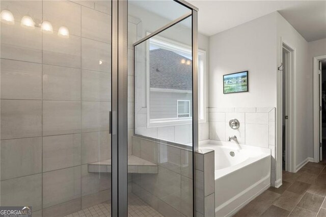 full bathroom featuring a bath and a shower stall