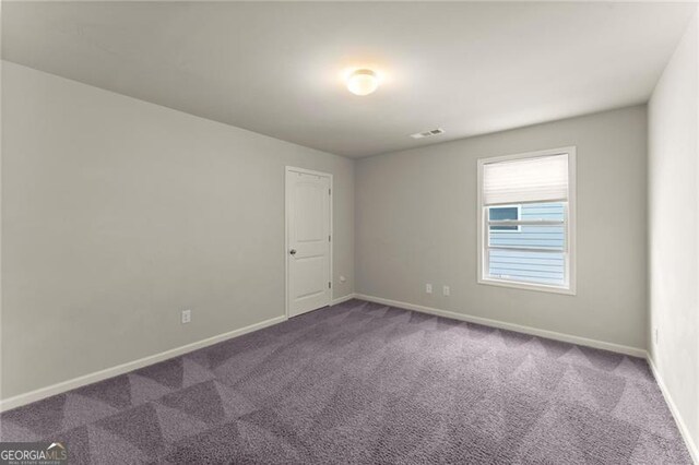 spare room with carpet and baseboards