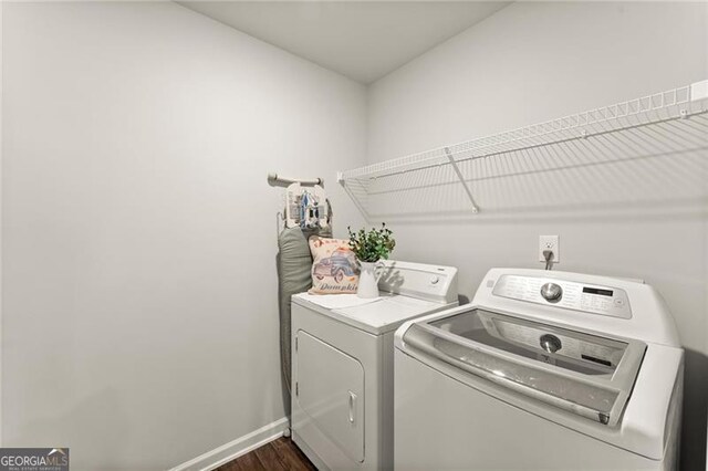 washroom featuring washer and clothes dryer, baseboards, and dark wood-style flooring